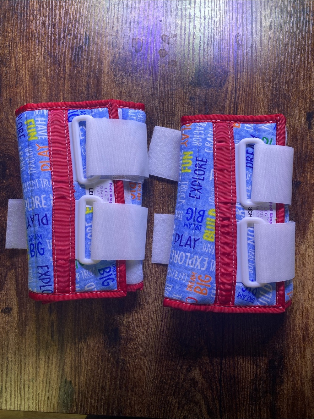 Kids leg Support Straps with Blue Word Print and Red Trim left and right